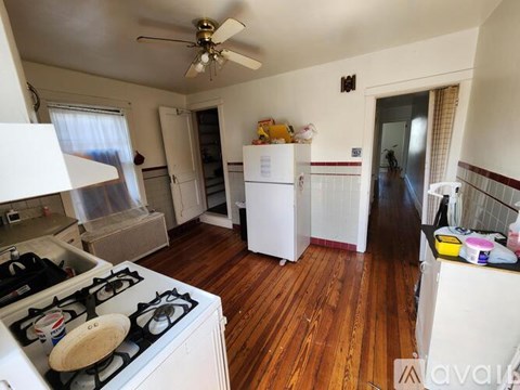 A kitchen with a white stove top and a white refrigerator.