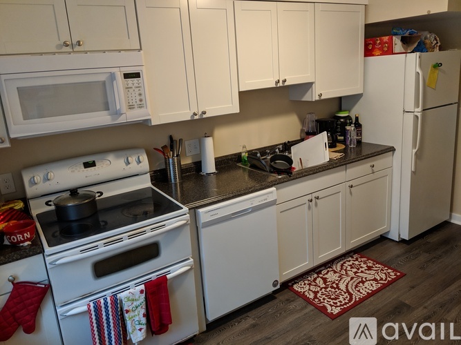 A kitchen with white appliances and cabinets.