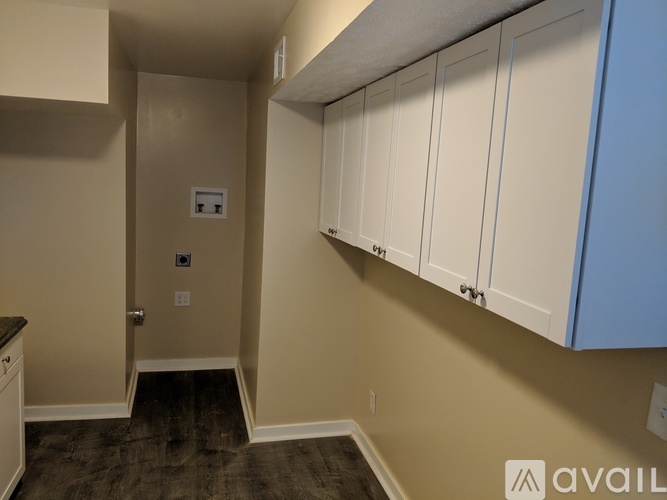 A hallway with a door and a wall-mounted electrical outlet.