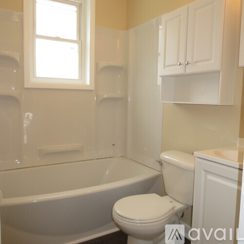 A white toilet sits next to a bathtub in a bathroom.