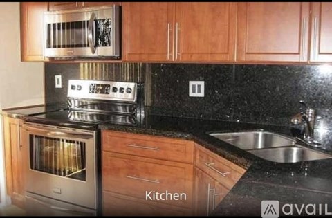 A kitchen with wooden cabinets and black countertops.