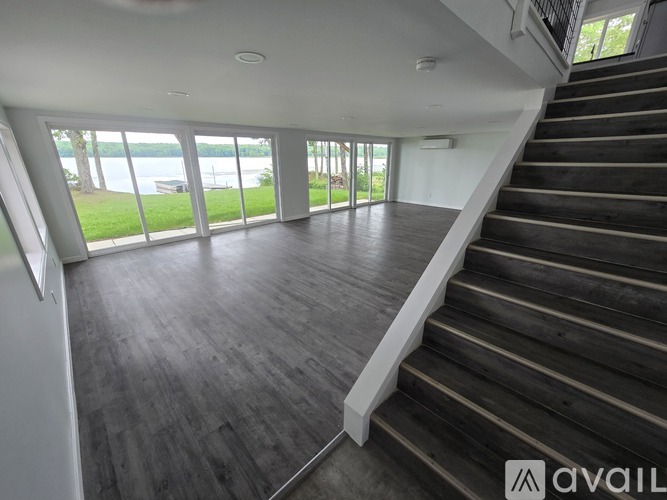 A spacious room with a staircase leading to the upper floor.
