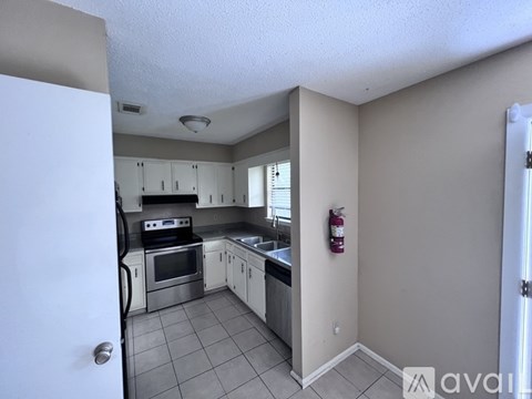 A kitchen with white cabinets and appliances.