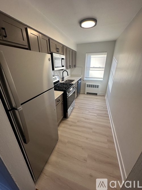 A kitchen with a refrigerator, microwave, and oven.