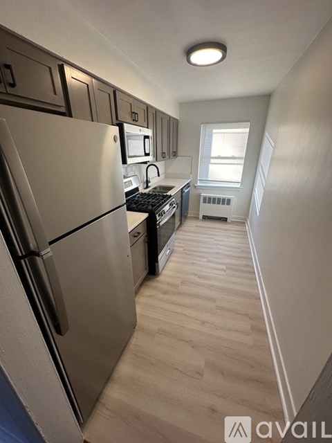 A kitchen with a refrigerator, microwave, and oven.