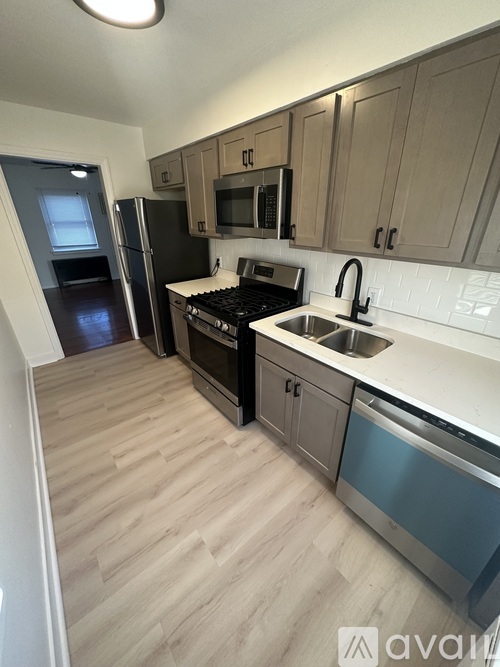 A kitchen with wooden floors and stainless steel appliances.