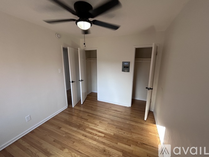 A room with a ceiling fan and wooden flooring.
