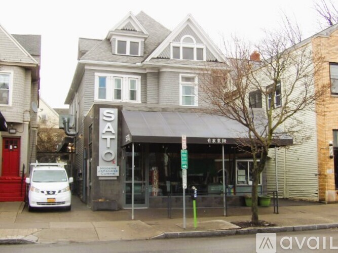 A Sato storefront with a white van parked in front.