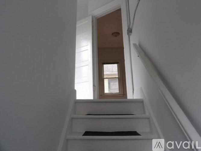 A staircase with a black mat on the bottom step.