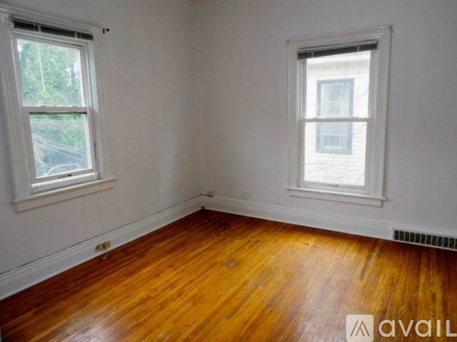 A room with wooden floors and two windows.