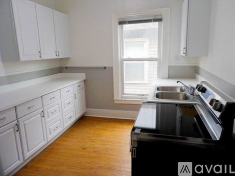 A kitchen with white cabinets and a black dishwasher.