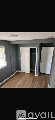 A room with a wooden floor and grey walls.
