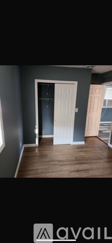 A room with a white door and grey walls.
