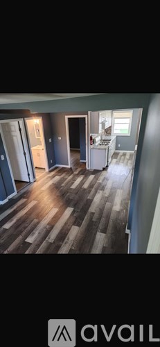 A room with wooden flooring and a white cabinet.