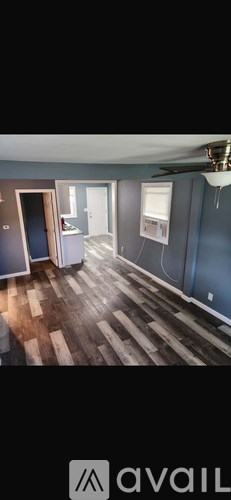 A room with wooden flooring and a ceiling fan.