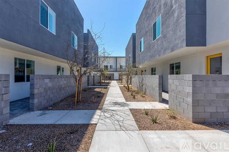 A modern building with a concrete exterior and a pathway leading to the entrance.