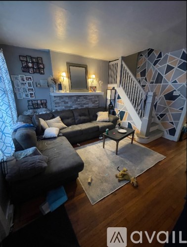 A living room with a grey couch and a wooden floor.