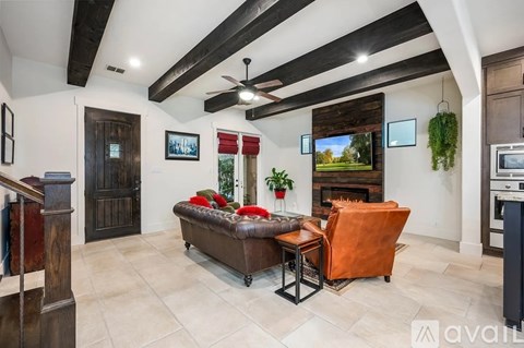 A modern living room with a brown leather couch and a wooden cabinet.