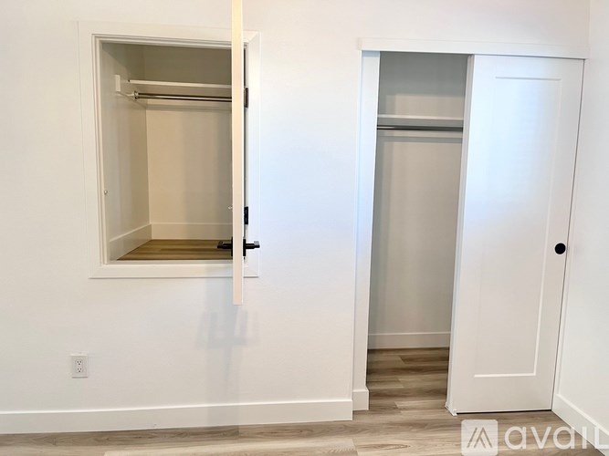 A white door with a small window is open.