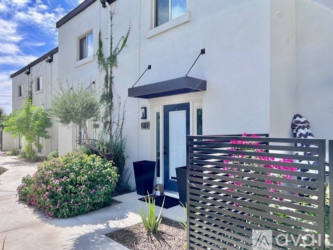 A white house with a black door and a black awning.