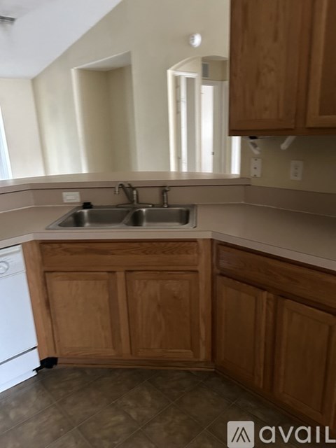A kitchen with wooden cabinets and a white dishwasher.