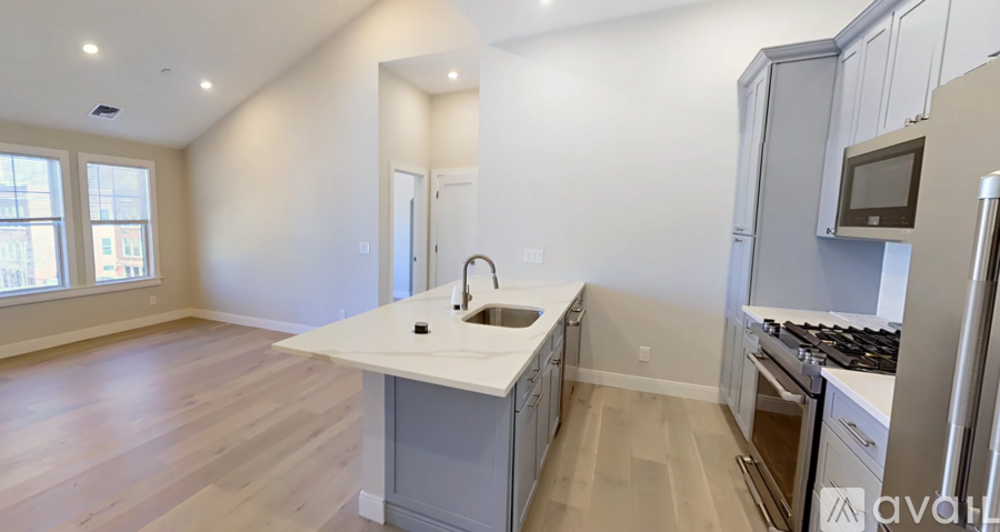 A kitchen with a white countertop and stainless steel appliances.