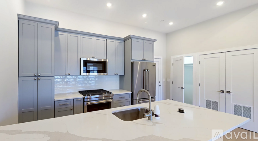 A modern kitchen with a large island and stainless steel appliances.