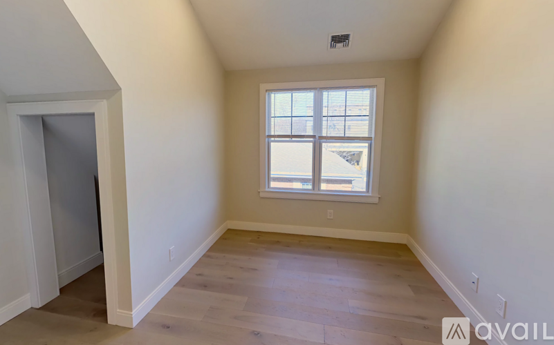 A room with a window and wooden flooring.