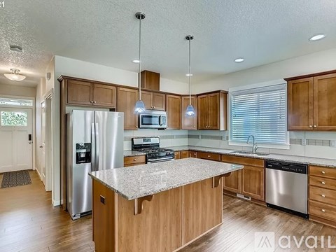 A kitchen with wooden cabinets and a granite countertop.