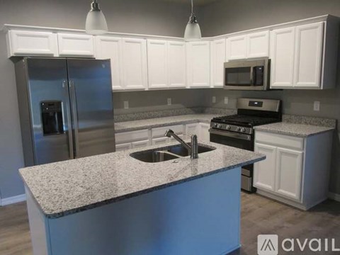 A kitchen with a granite countertop and stainless steel appliances.