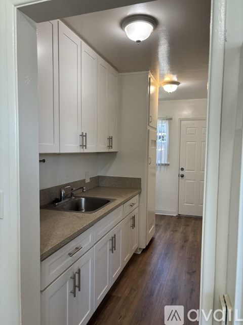 A kitchen with white cabinets and a sink.
