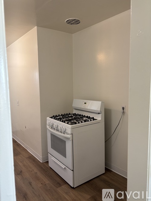 A white stove and oven in a room with wooden floors.
