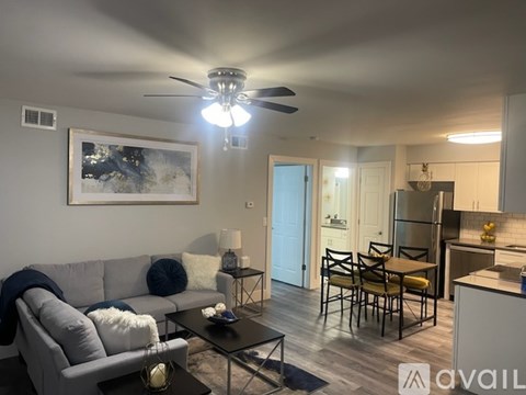 A living room with a grey couch, a coffee table, and a painting on the wall.