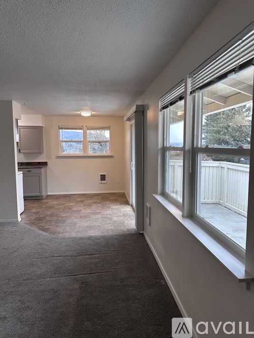 A room with a white door and a window with blinds.