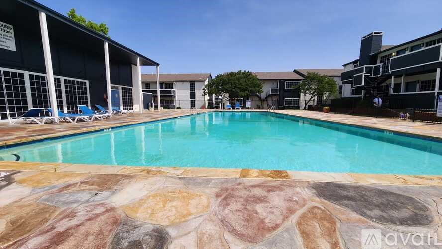 A large outdoor swimming pool with a stone border.
