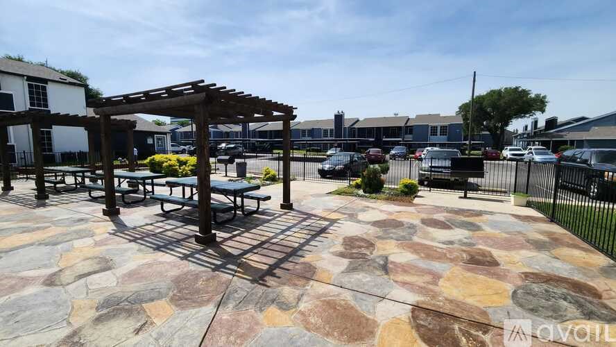 A patio area with a stone floor and a pergola.