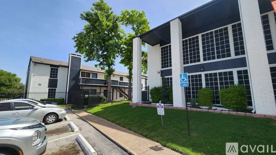 A parking lot with cars and a building in the background.