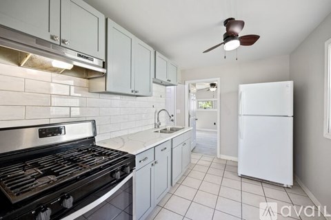 A kitchen with white cabinets and a black stove top oven.