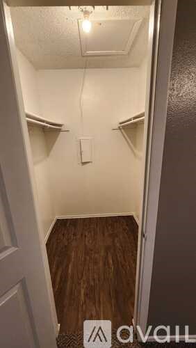 A small, narrow hallway with wood flooring and white walls.