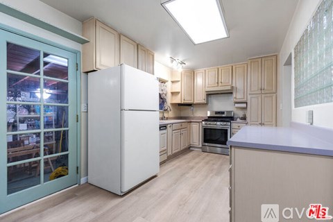 A kitchen with wooden cabinets and a white refrigerator.