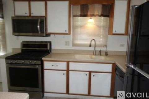 A kitchen with white cabinets and a black oven.