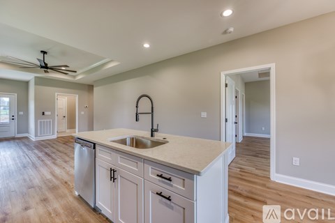 A kitchen with a sink and a fan on the ceiling.