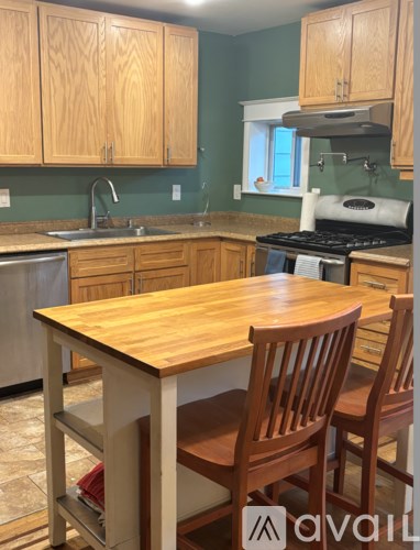 A kitchen with a table and chairs.