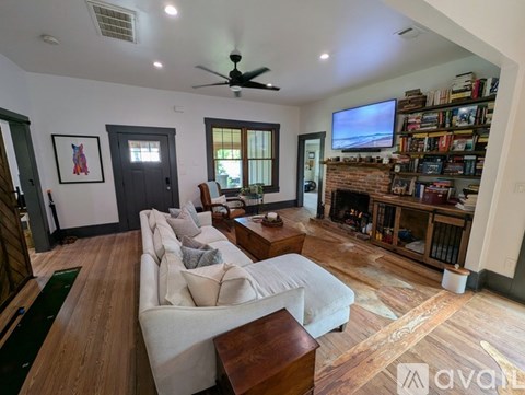 A living room with a white couch and a fireplace.