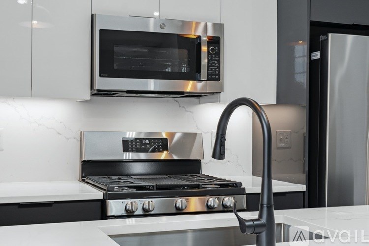 A modern kitchen with a stainless steel oven and microwave above it.