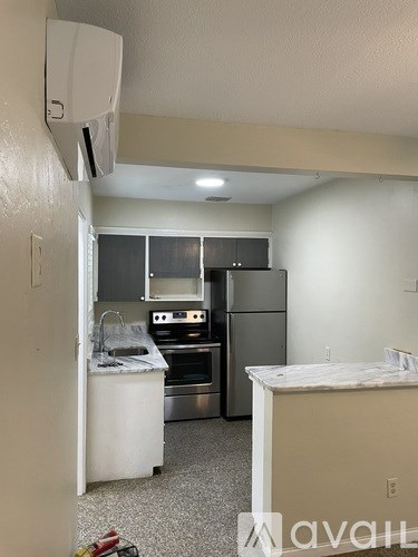 A kitchen with a refrigerator, microwave, oven, and sink.