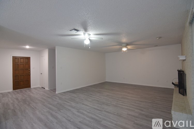 A room with a ceiling fan and a wooden door.