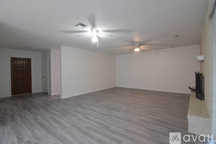 A spacious room with a ceiling fan and a television on the wall.