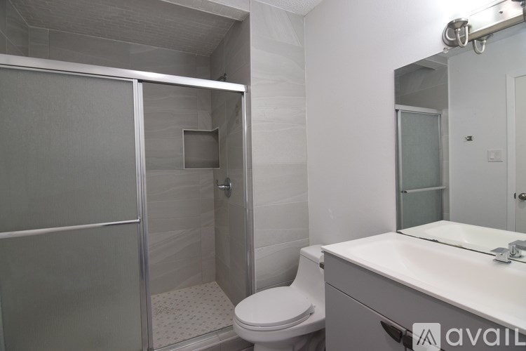 A bathroom with a toilet, sink, and shower.