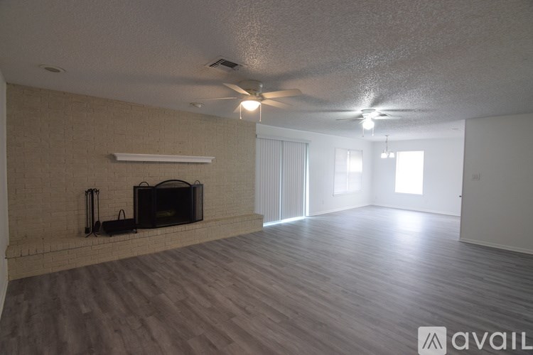 A spacious living room with a fireplace and hardwood floors.
